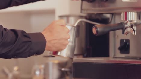 Barista-steaming-milk-at-the-coffee-machine