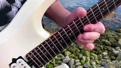 a guitarist plays near the water of the lake