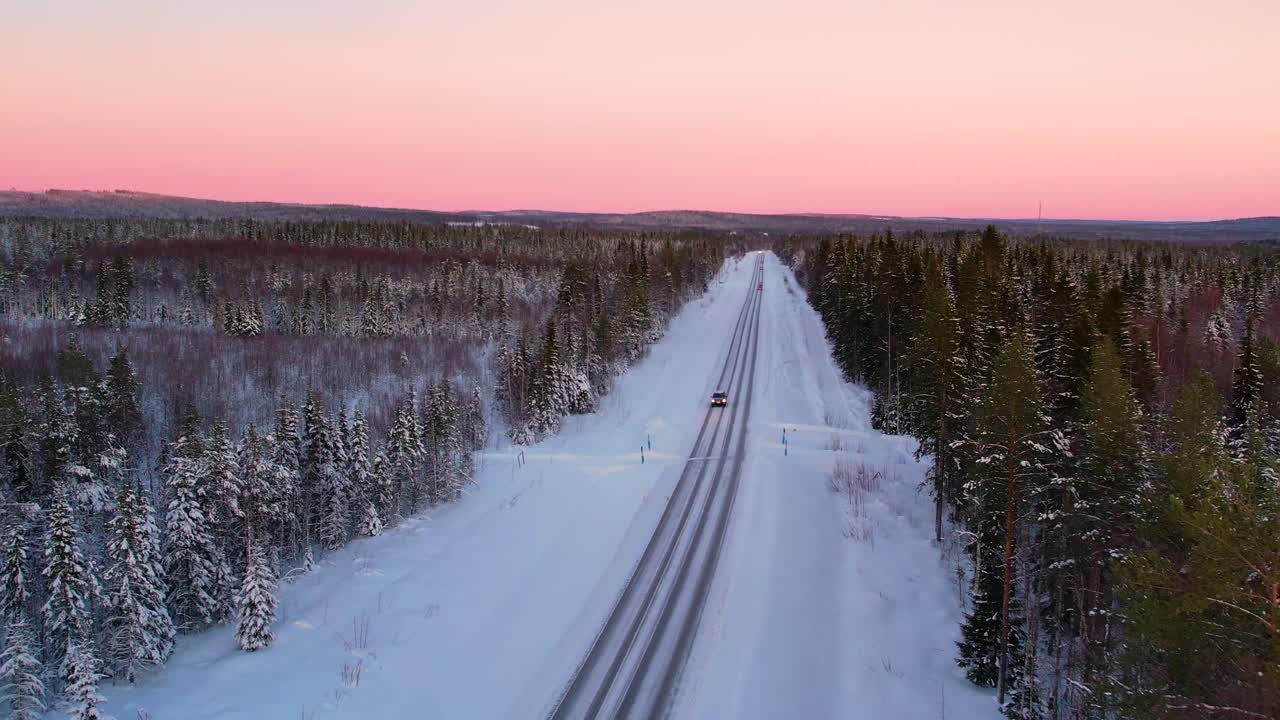 Driving through a snowy winter forest at sunset