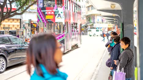 4k timelapse of downtown hong kong with people wait railroad track at tram station