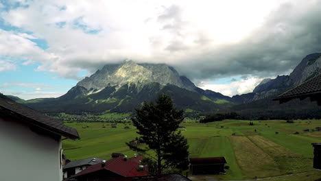 the zugspitze mountain seen across a lush green valley in the alps