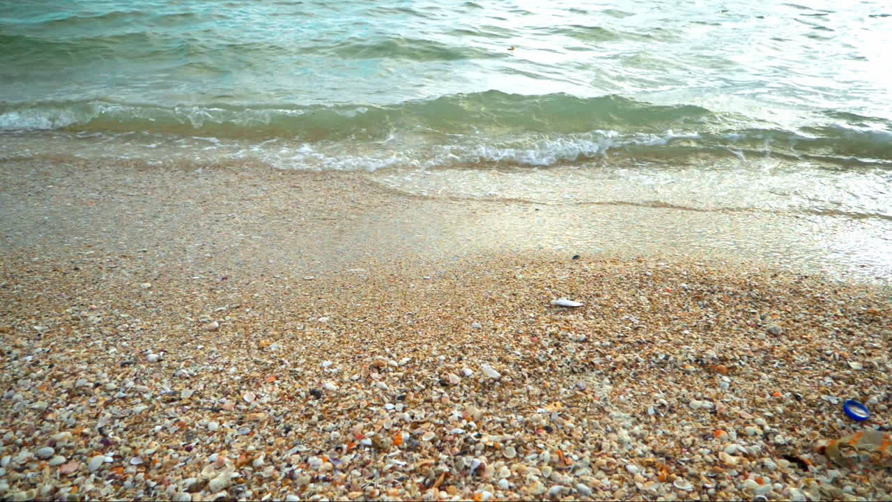 해가 지는 동안 열대 지방의  ⁇  모래 해변의 해안에 도달하는 파도와 함께 아름다운 해변