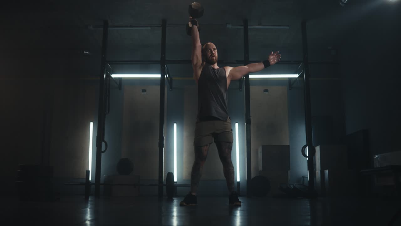 hombre realizando ejercicios de kettlebell en el gimnasio