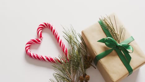 video of two christmas canes and decorations over white background