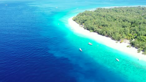 beautiful tropical island with lush vegetation and white sandy beach, tourists coming by boats on shore, sailing across blue turquoise lagoon, indonesia