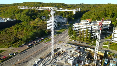 Dos-Grúas-Torre-Planas-En-Un-Proyecto-De-Construcción-En-Gdynia,-Polonia---Tiro-De-Dron-Descendente