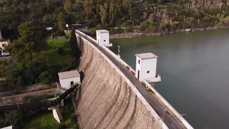 Water-reservoir-dam-in-South-Sardinia,-Tratalias,-establisher-shot-above-road