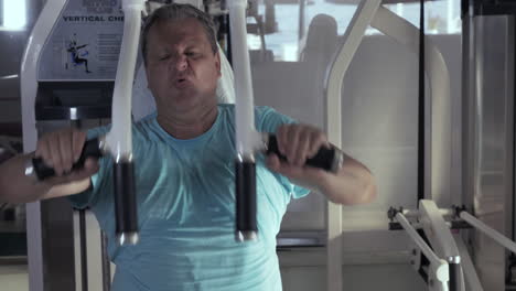 close-up of grown man in gym performs exercises chest press