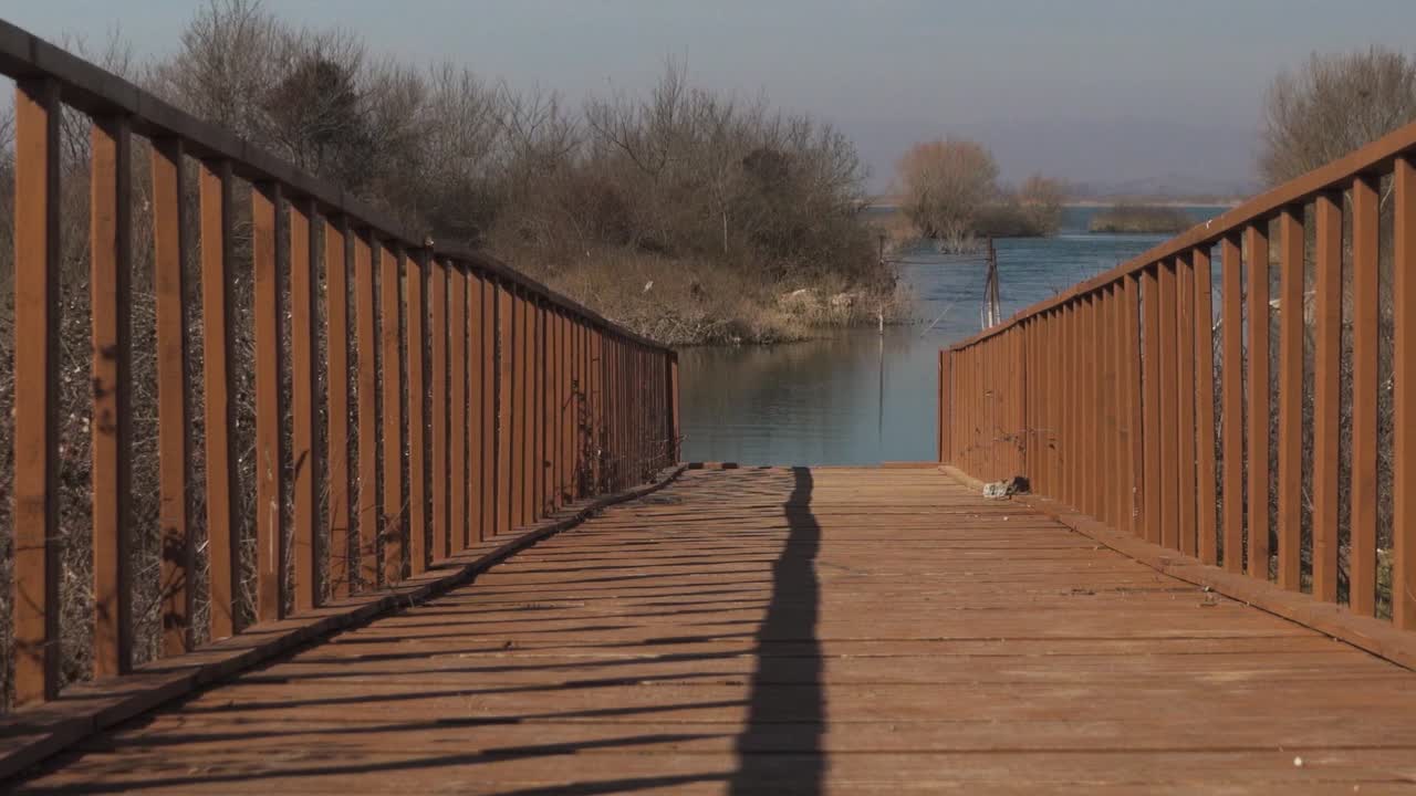 Wooden pier sits empty on beautiful breezy day at the river bank, calmness concpet