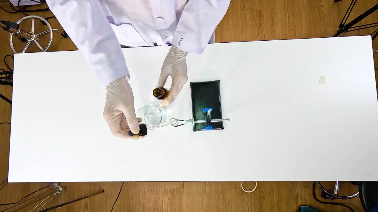 Scientist conducts a chemical reaction using lead nitrate and potassium iodide in a controlled laboratory setting