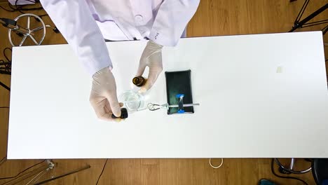 scientist conducts a chemical reaction using lead nitrate and potassium iodide in a controlled laboratory setting