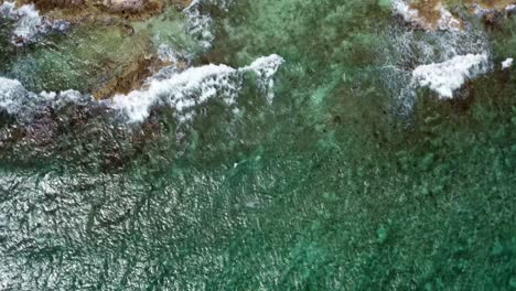 Drohne-Fliegt-über-Klares-Türkisfarbenes-Wasser-Und-Erreicht-Wellen,-Die-In-Felsen-Eines-Tropischen-Kargen-Strandes-Mit-Weißem-Sand-Und-Palmen-An-Der-Riviera-Maya,-Mexiko,-In-Der-Nähe-Von-Cancun,-Einschlagen