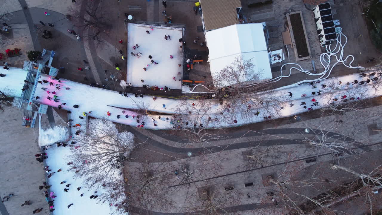 Aerial perspective of circular skating routes near residential buildings and snow banks
