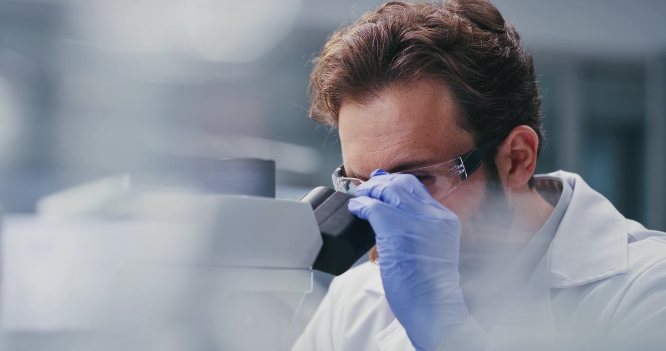 Scienziato che usa il microscopio in laboratorio