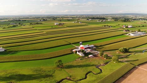 descending aerial shot of farm and striped fields during summer in strasburg, lancaster county, pennsylvania