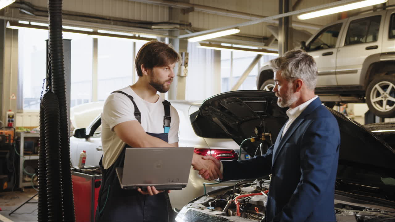 mecánico asesorando a un cliente en un taller de reparación de automóviles