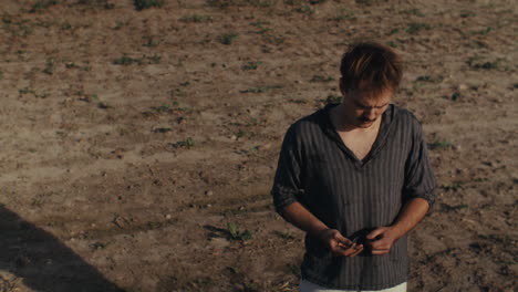 man standing in a barren field