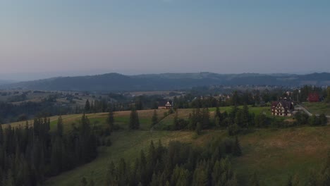 countryside with wooden chalet houses on polish highlands in cyrhla, podhale region, southern poland