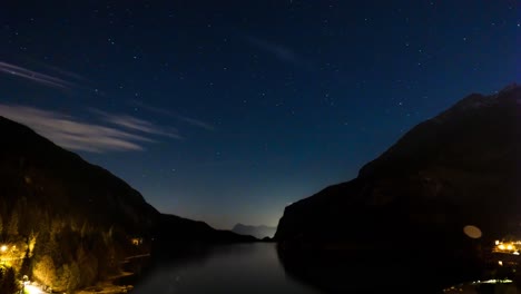 Lapso-De-Tiempo-Estrellas-Y-Nubes-Pasando-Sobre-El-Lago-Molveno-En-Trentino,-Italia-Por-La-Noche