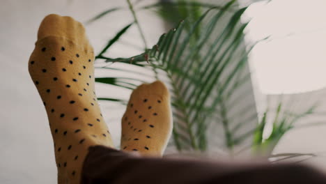 Man-feet-with-fashion-and-relax-socks-on-the-sofa