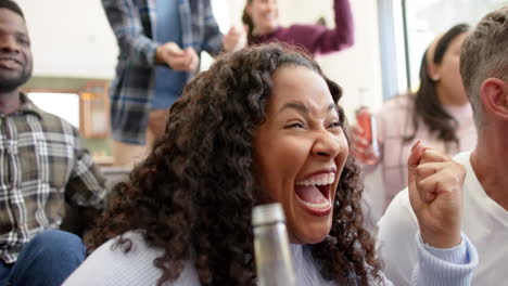 happy diverse male and female friends watching sport on tv and celebrating victory