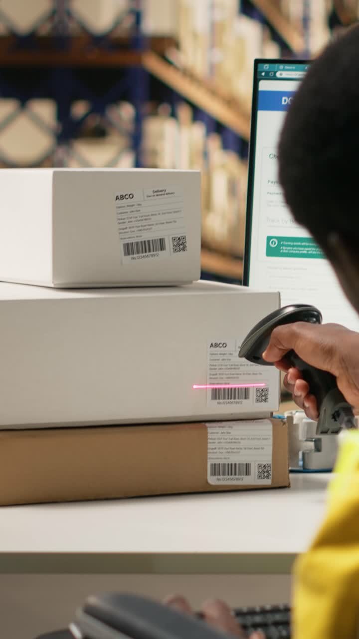 Vertical Video African american wheelchair user works on package tracking info in depot