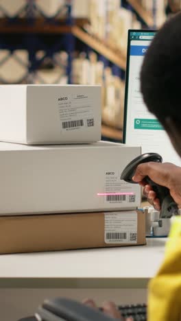 vertical video african american wheelchair user works on package tracking info in depot