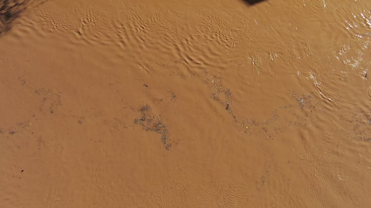 진흙 투성이의 공중, 무서운 급류 급류로 하류로 떠 다니는 잔해