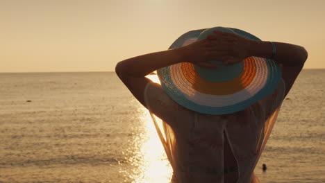 Una-Mujer-Con-Sombrero-Espera-Con-Ansias-El-Amanecer-Sobre-El-Mar-Vacaciones-Y-Concepto-De-Vacaciones