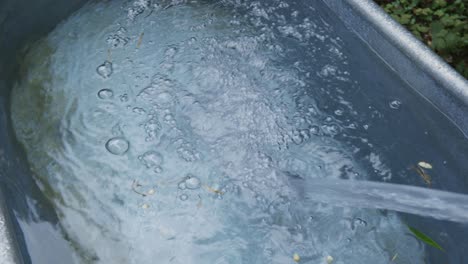 filling a galvanized tub with cold water background close up