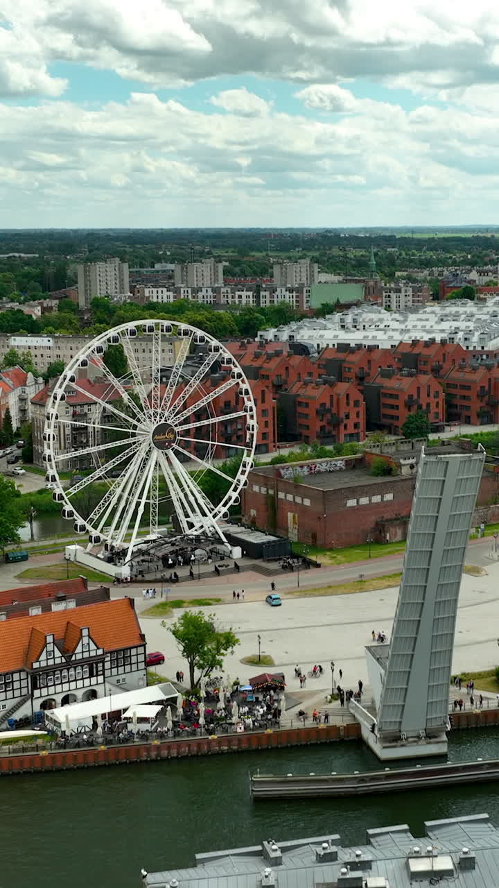 Ripresa aerea di Danzica, in Polonia, che mostra la ruota panoramica AmberSky e il ponte levatoio sul fiume Motława. Ottima per contenuti di viaggio e turismo
