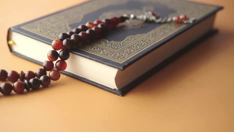 holy book quran and rosary on table, close up.