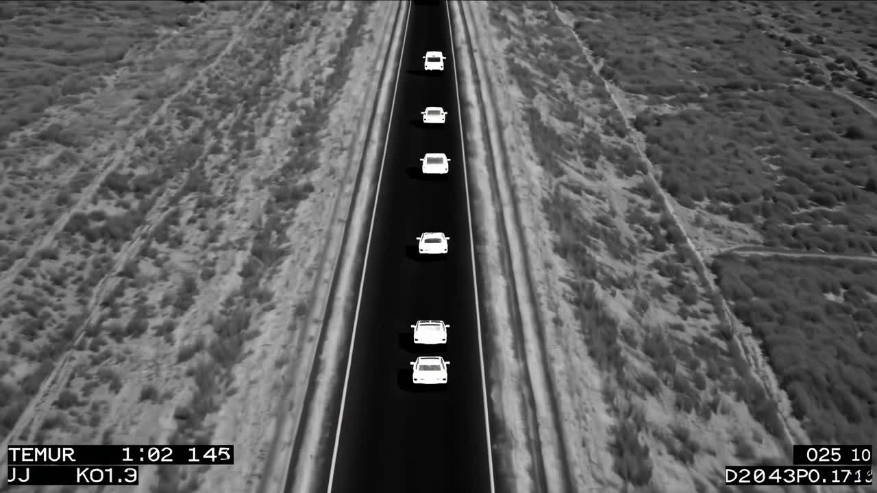 Sequence of white cars driving along a straight highway surrounded by textured terrain, showcasing continuous motion and dynamic road travel