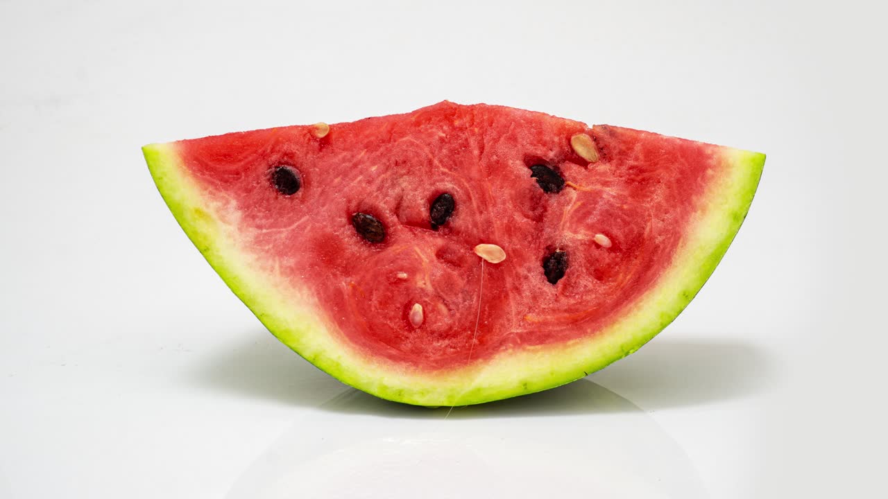 un pedazo de sandía madura podrida sobre un fondo blanco, lapso de tiempo, video cognitivo educativo