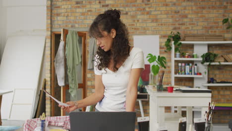 biracial woman stands in a creative home office