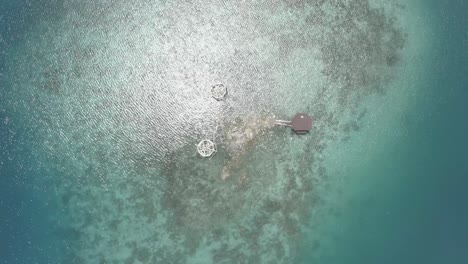 Top-down-View-Of-A-Luxury-Cottage-Resort-In-The-Middle-Of-A-Crystal-Clear-Blue-Water-In-The-Tropical-Island-Of-The-Philippines-On-A-Bright-Weather