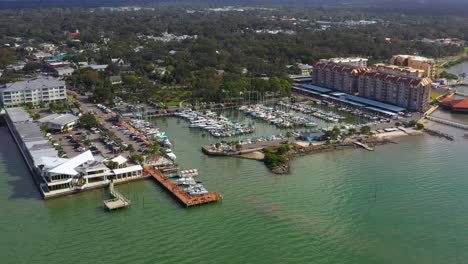 drone footage over downtown dunedin, florida marina with boats and the gulf of mexico and tampa bay