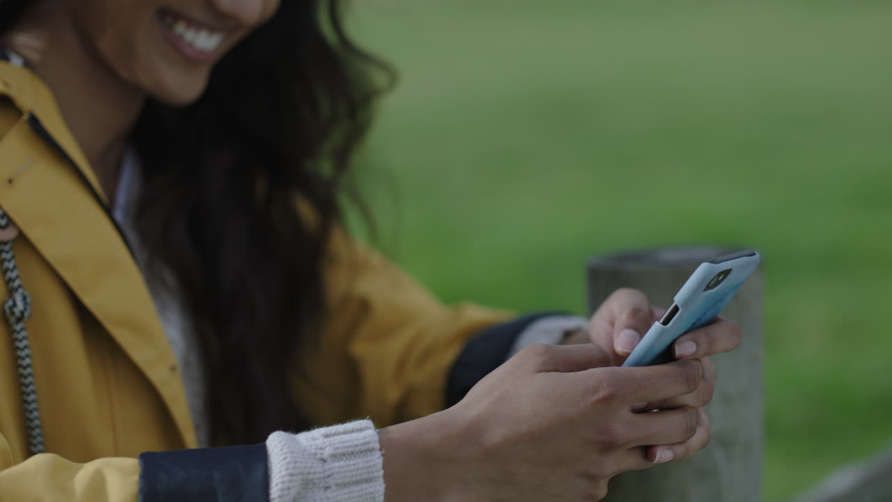 close up giovane donna indiana che scrive messaggi usando smartphone tecnologia mobile sorridendo godendo di condividere avventura esperienza di viaggio messaggi online social media