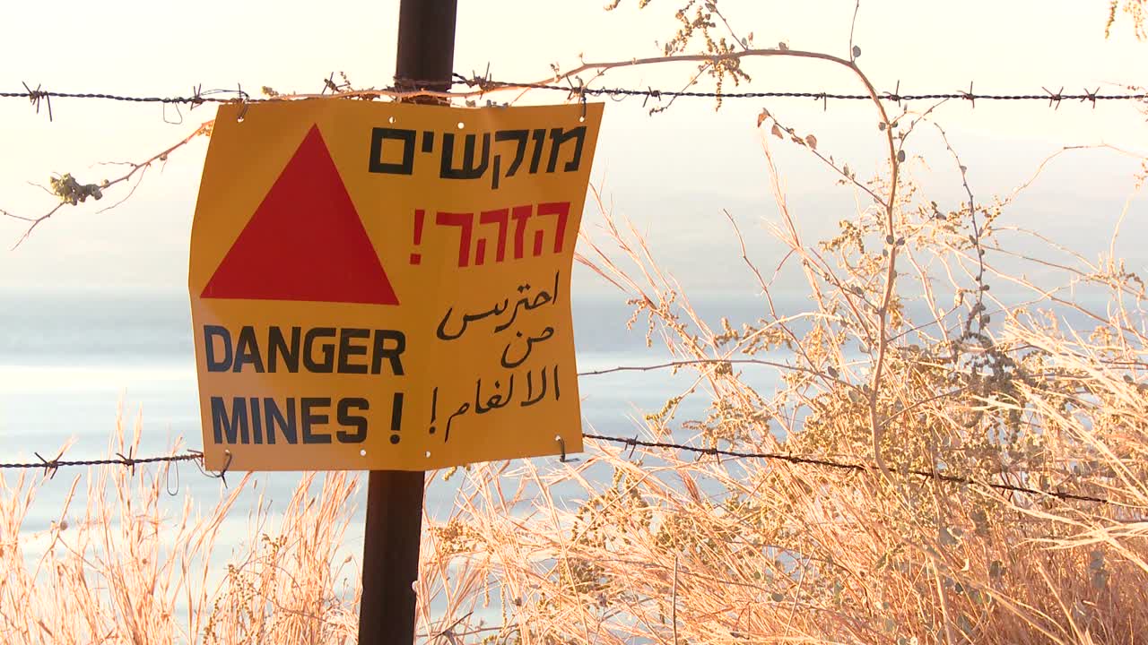 Un cartello avverte in inglese, arabo ed ebraico che ci sono mine nelle vicinanze lungo il confine di Israele con la Siria.