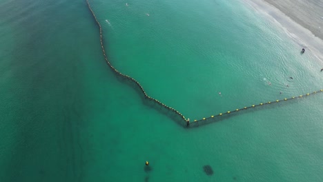 People-swimming-at-morning-into-shark-protective-net,-Coogee-Beach-in-Australia