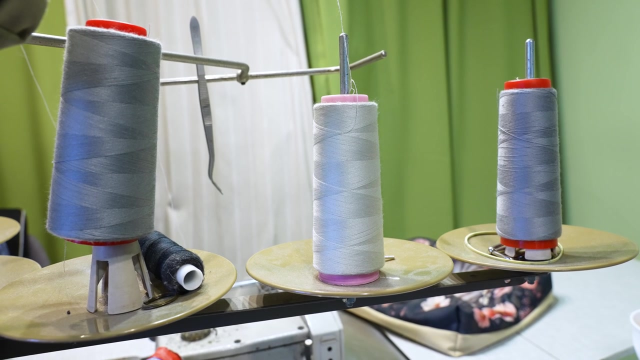 Multiple thread bobbins on a spool holder of an industrial sewing machine