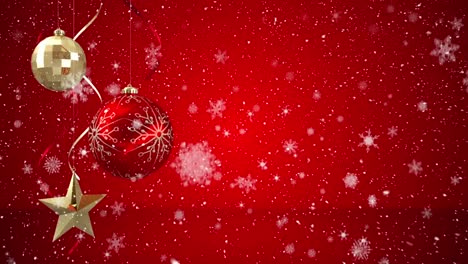 animation of snow falling over red and gold christmas baubles decoration