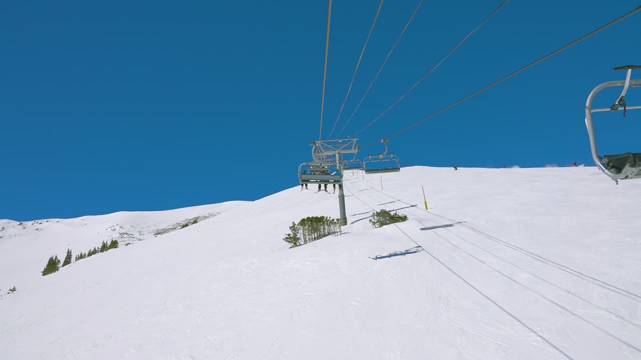 푸른 하늘과 함께 높은 눈 인 산꼭대기 꼭대기에 의자 엘리베이터를 타고