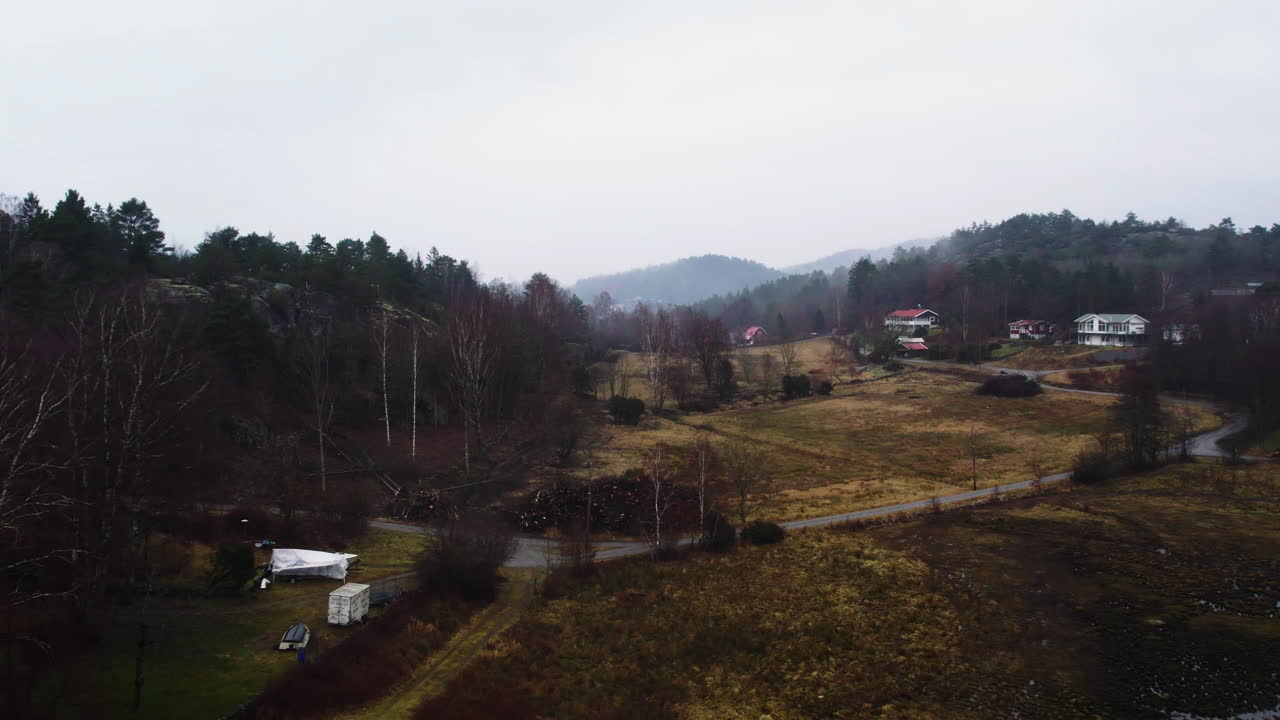 Luftaufnahme über der Landschaft von Orust mit verstreuten Villen an einem nebligen Tag, Schweden, Drohnenaufnahme