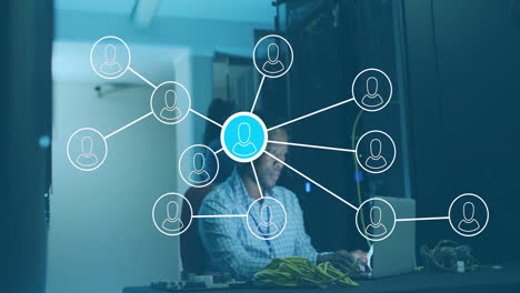 network connections animation over person working on laptop in server room