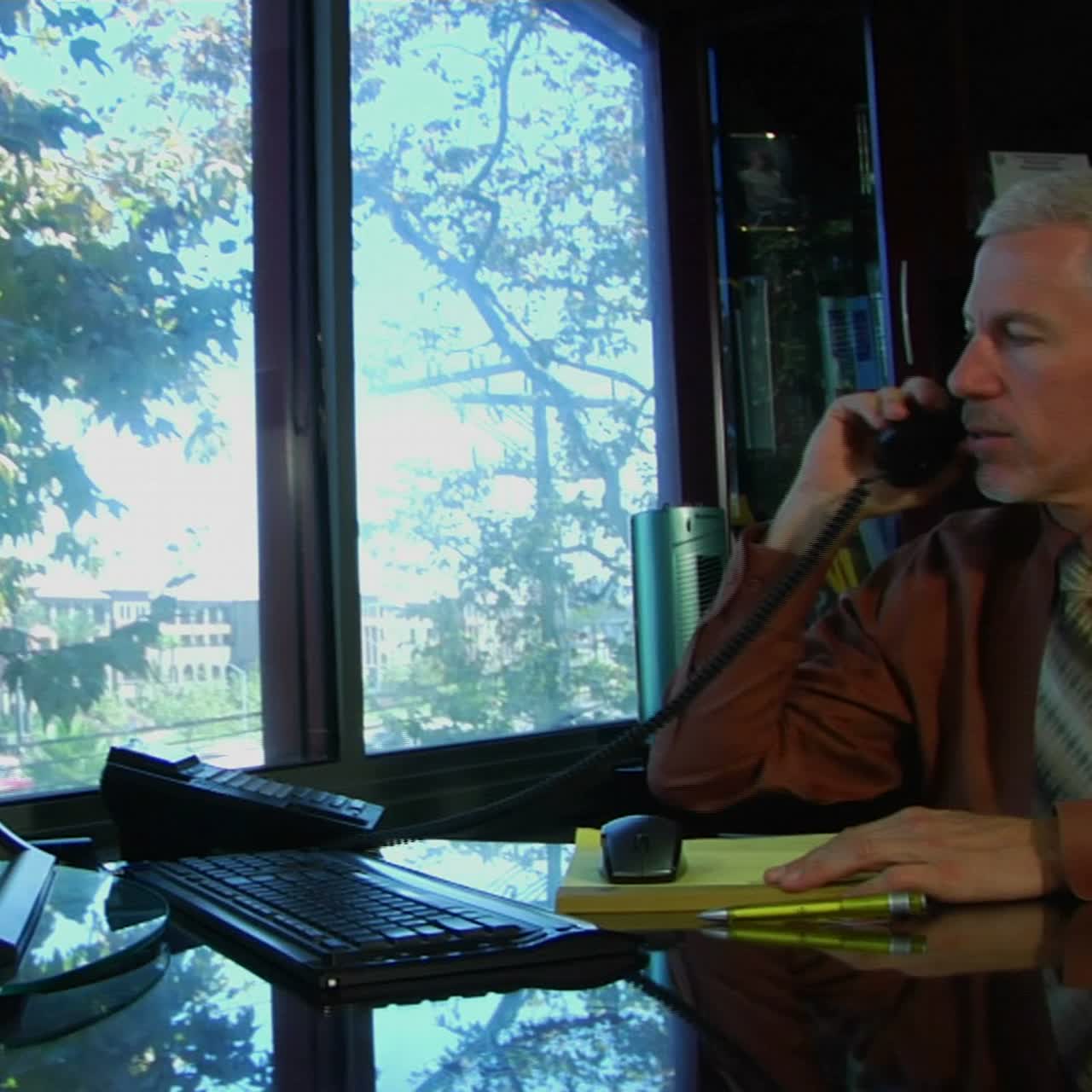 un hombre de negocios habla por teléfono y trabaja en una computadora