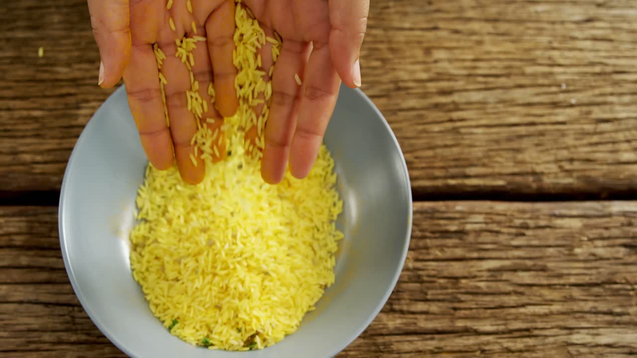 manos vertiendo arroz en un cuenco 4k