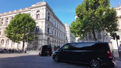 motorcade passing grand government buildings on a sunny day in london