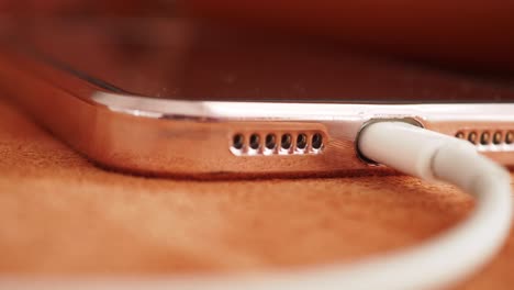 rose gold smartphone charging with white cable