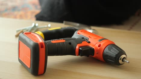 orange battery drill on wooden surface